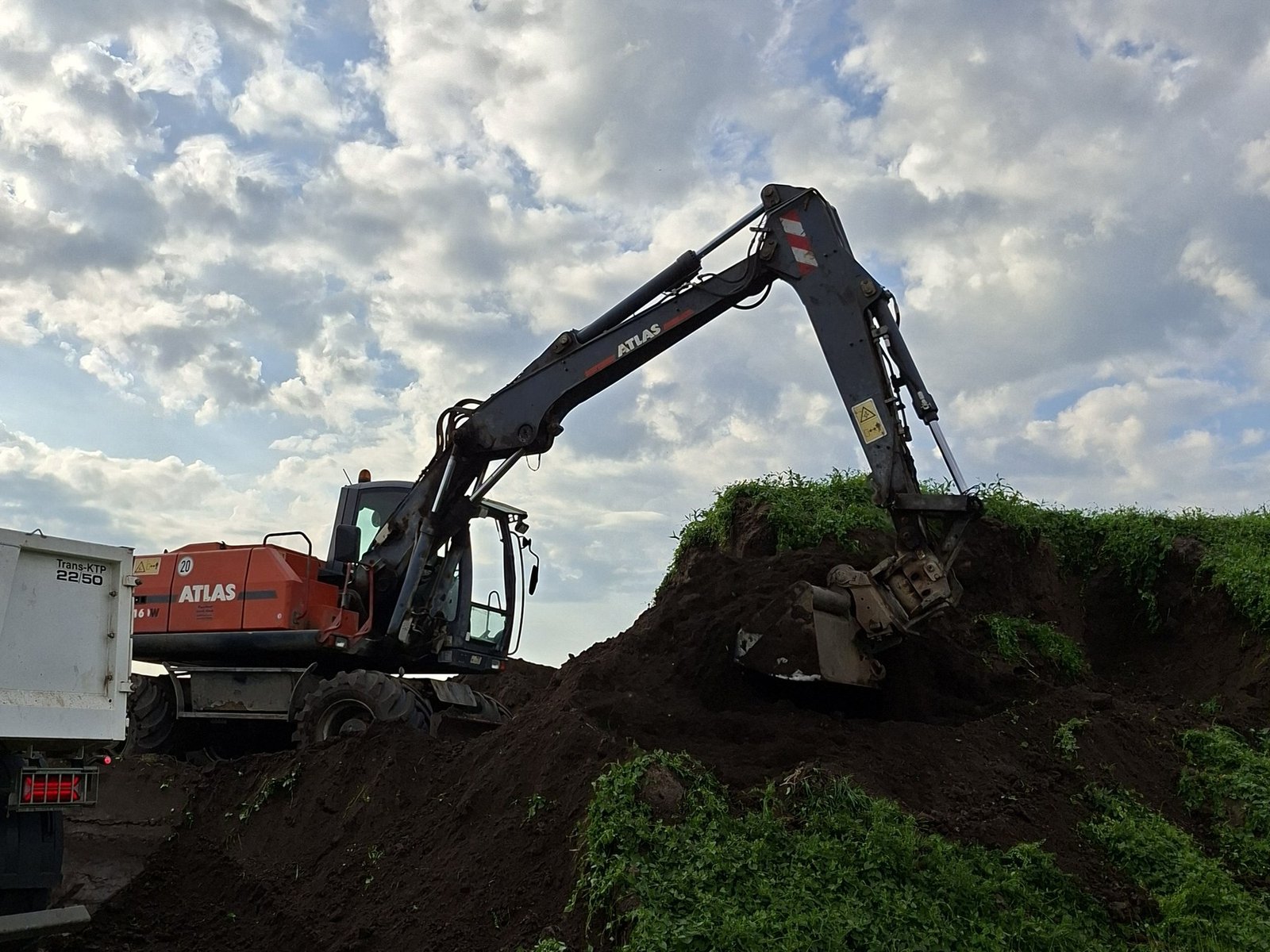 Atlas 160W Mobilbagger belädt einen Kipper mit Erde